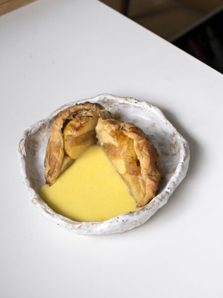 Aufgeschnittener Apfel im Schlafrock mit Weißwein-Chaudeau