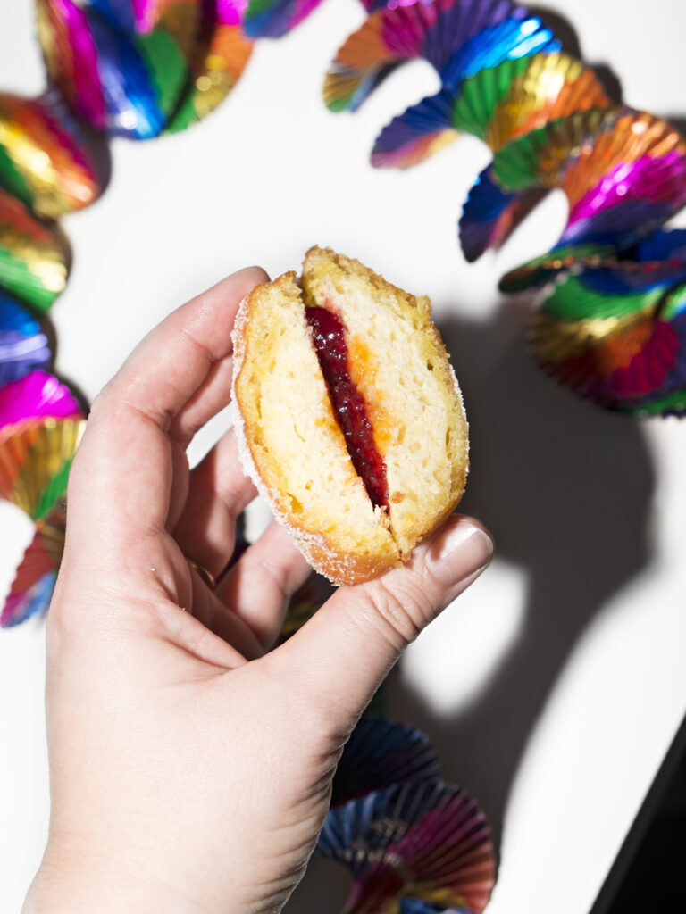 halbierter Krapfen gefüllt mit Himbeerkonfitüre